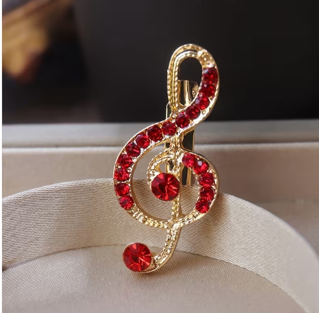 Stilinga sagė- Muzikos Raktas puoštas raudonais kristalais